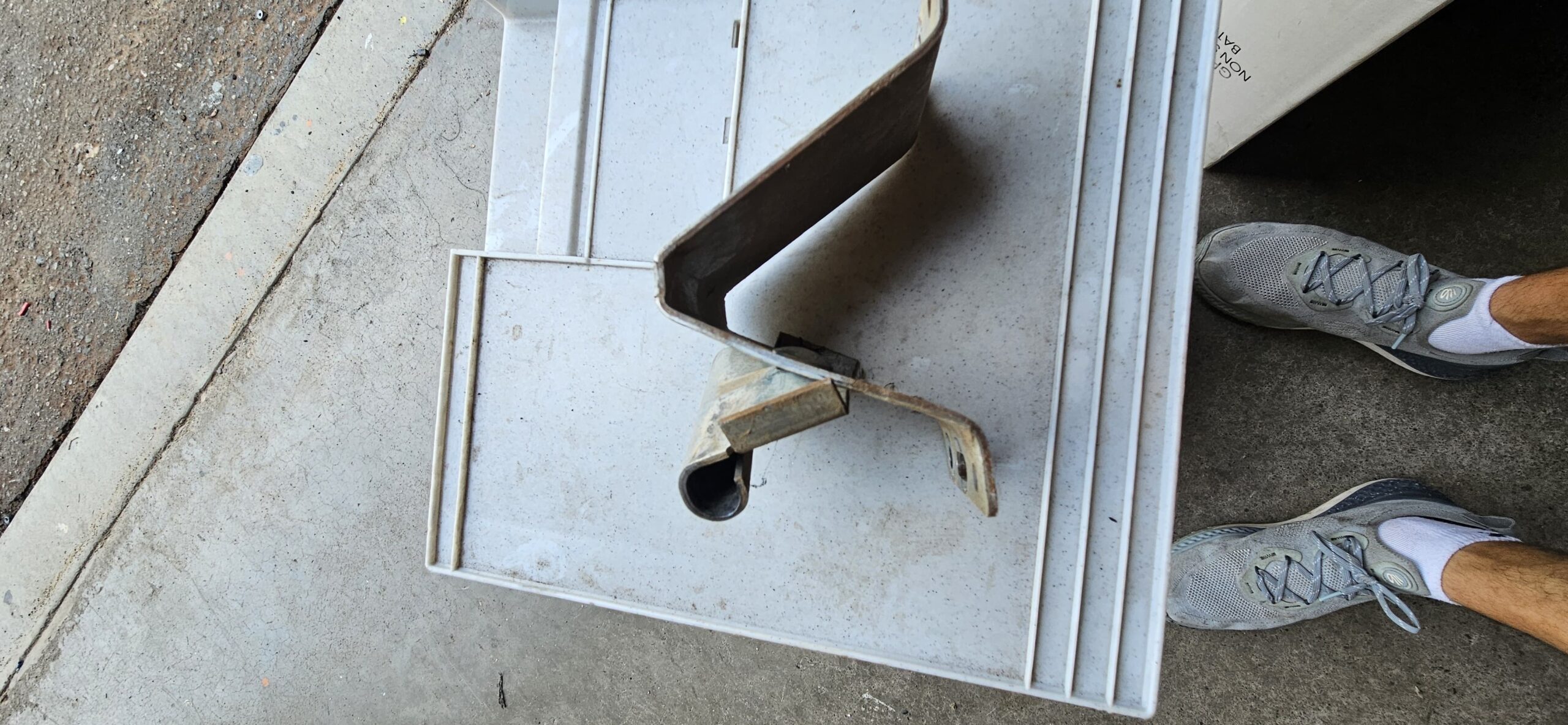 Close view of bent garage door bracket removed from a commercial door in Goodyear