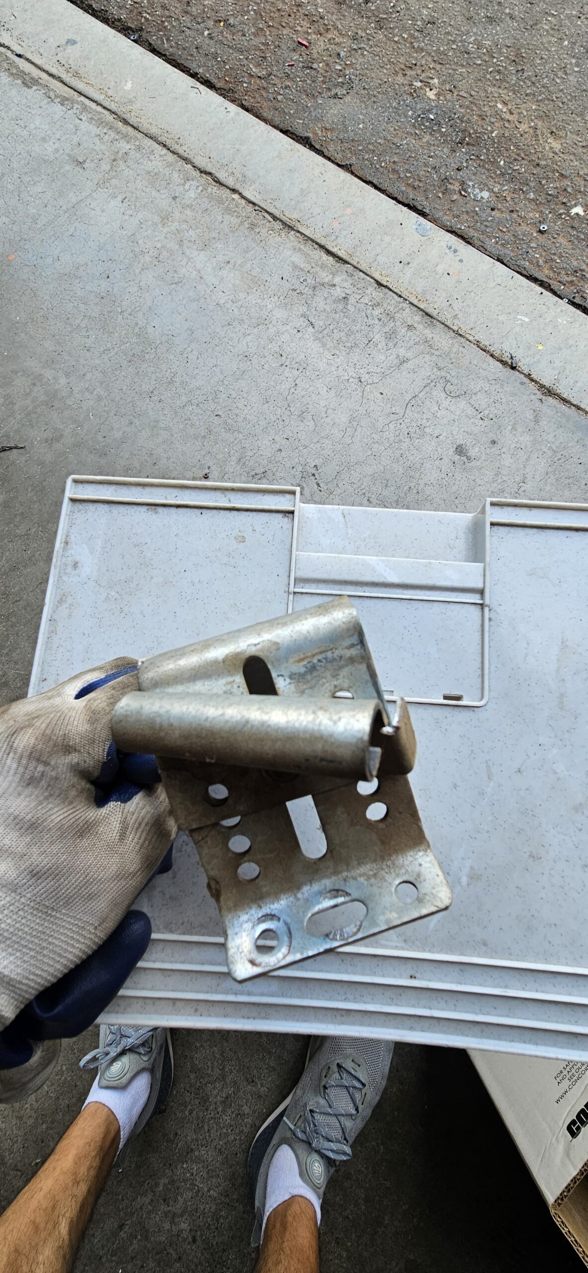 Damaged commercial garage door upper roller bracket removed during repair in Goodyear