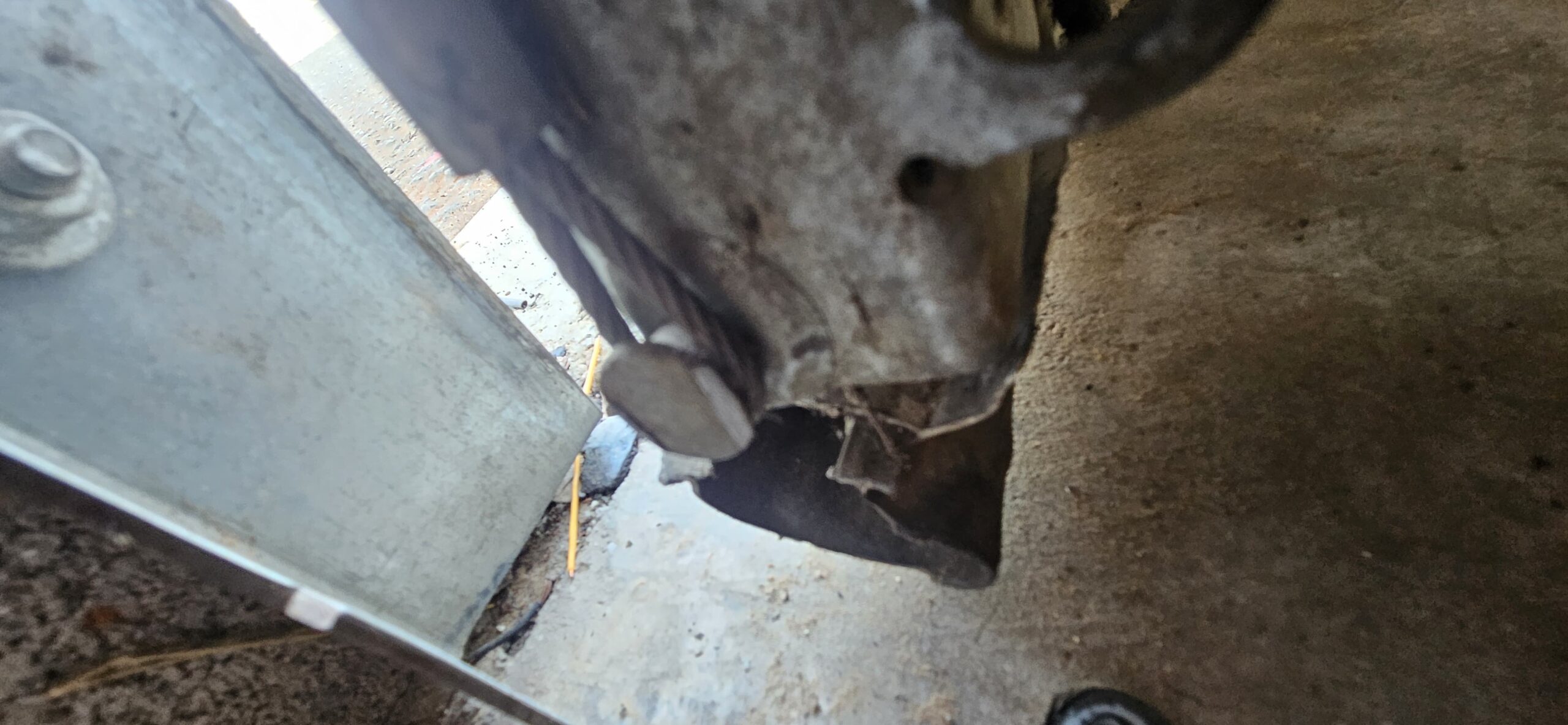 Existing lower commercial garage door hardware and cable area during inspection